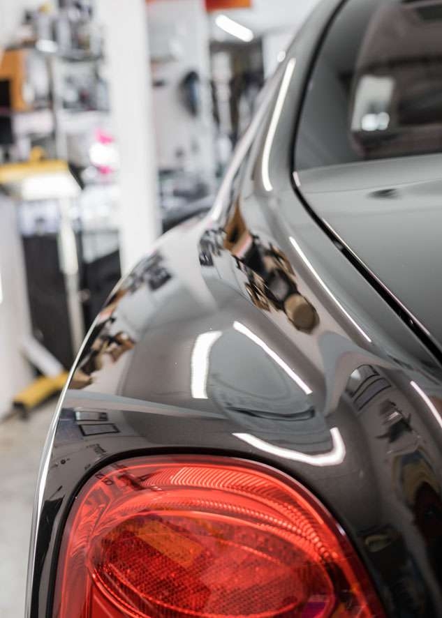 Shiny rear of Bentley Flying Spur car after paint oxidation removed by polishing, paint correction and Paintwork Enhancement