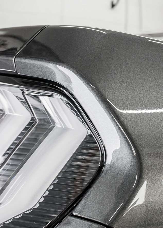 Close up of paint protection film (PPF) on rear light of grey Mustant GT car
