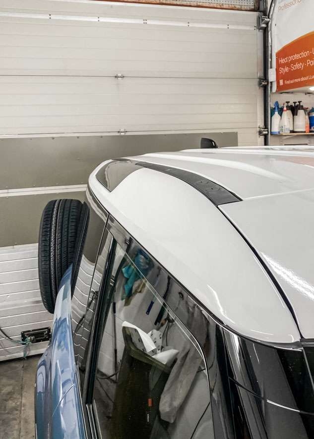 Blue Land Rover Defender with vinyl wrapped white roof