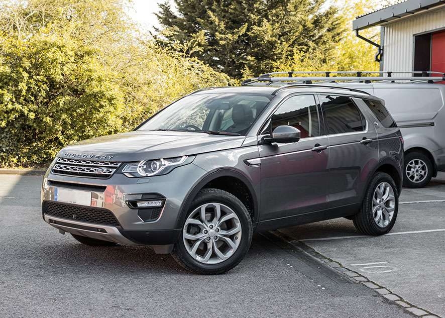 Grey Land Rover Defender with tinted side windows after window tinting