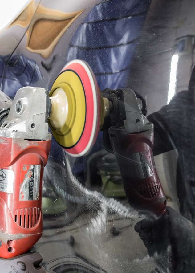 Big scratch on car paintwork being removed by machine polishing