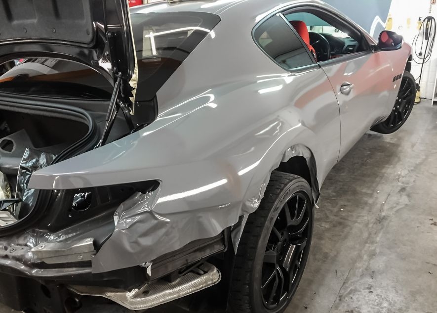 Maserati GranTurismo car being vinyl wrapped in khaki green