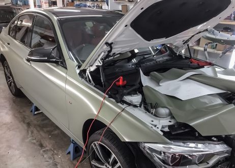 BMW 3 series car being vinyl wrapped in khaki green