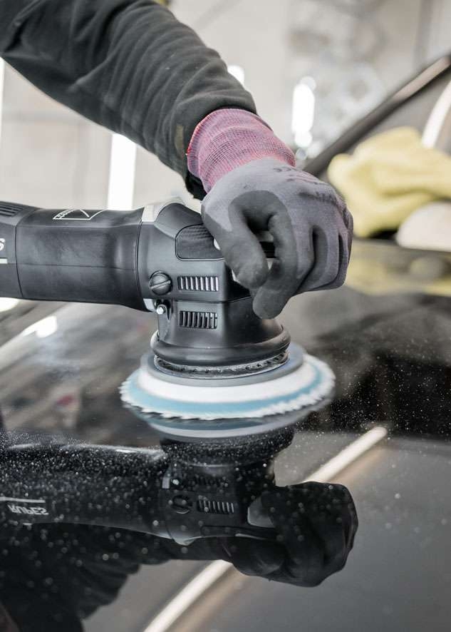 Bentley Flying Spur car being professionally polished using best equipment in glove