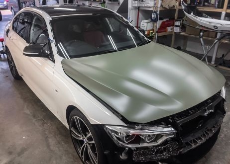 BMW 3 series car being vinyl wrapped in khaki green