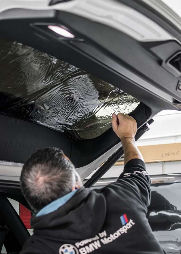 Rear window being tinted using LLumar window tinting film on White BMW X5