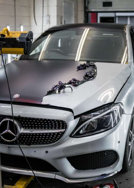 Purple vinyl wrap being removed from car grey Mercedes C Class