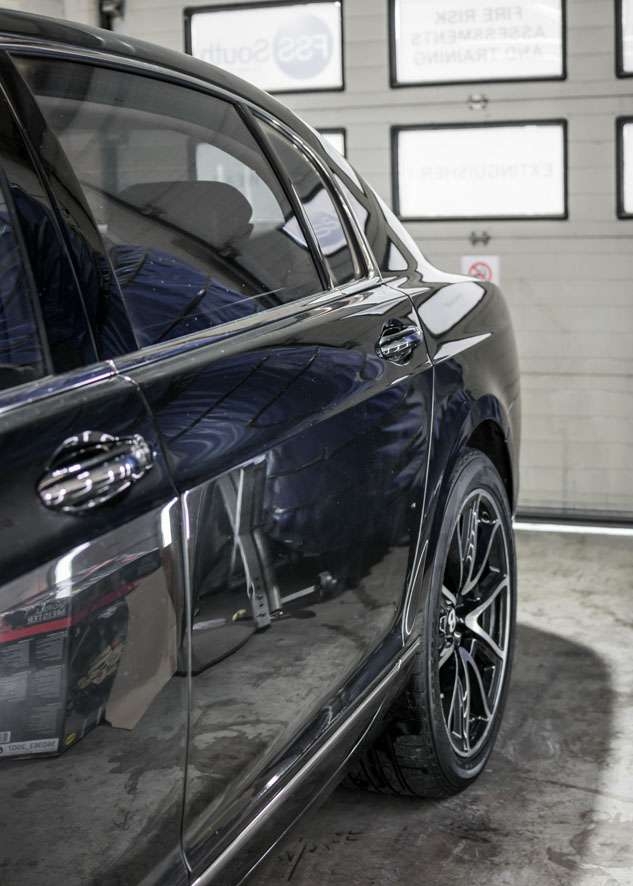 Rear side shot of Bentley Flying Spur car with dull paintwork