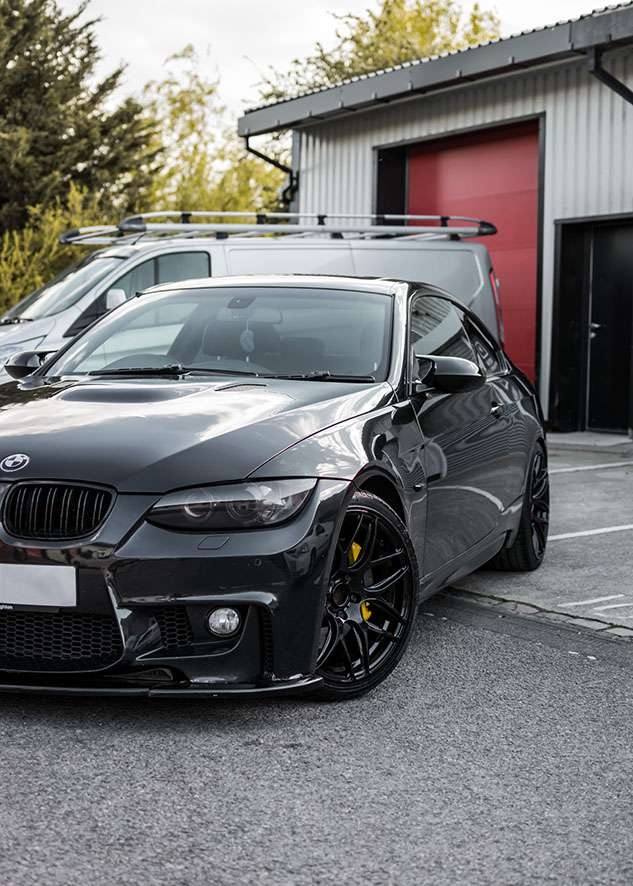 Front side shot of shiny BMW 335i car after paint correction, paintwork correction and lights tinting