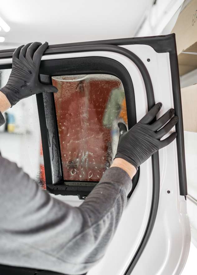 White Land Rover Defender car rear window being tinted
