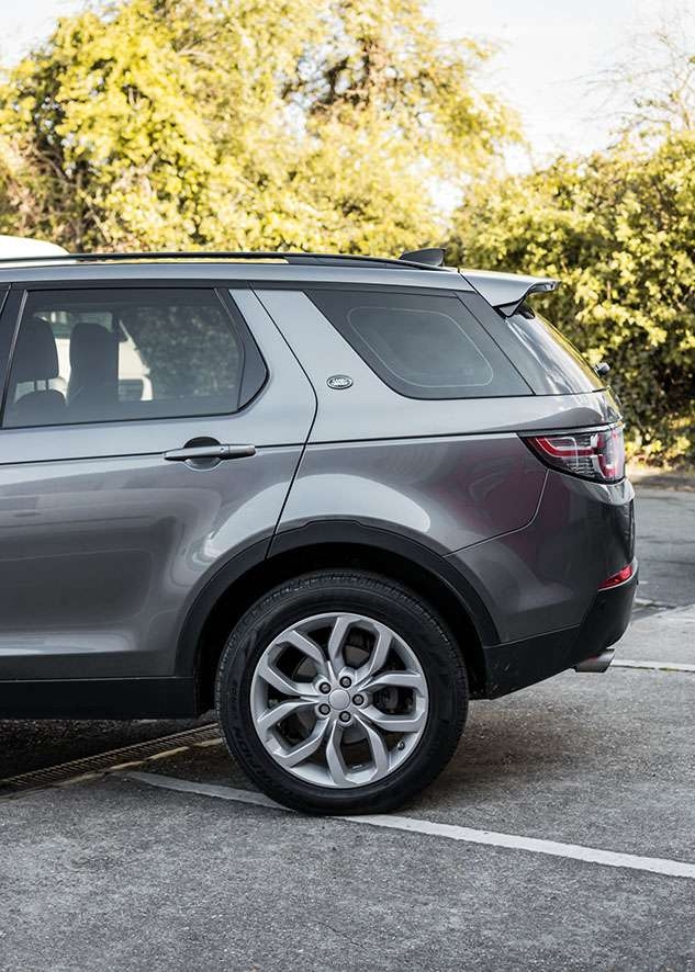 Grey Land Rover Defender with tinted side windows after window tinting