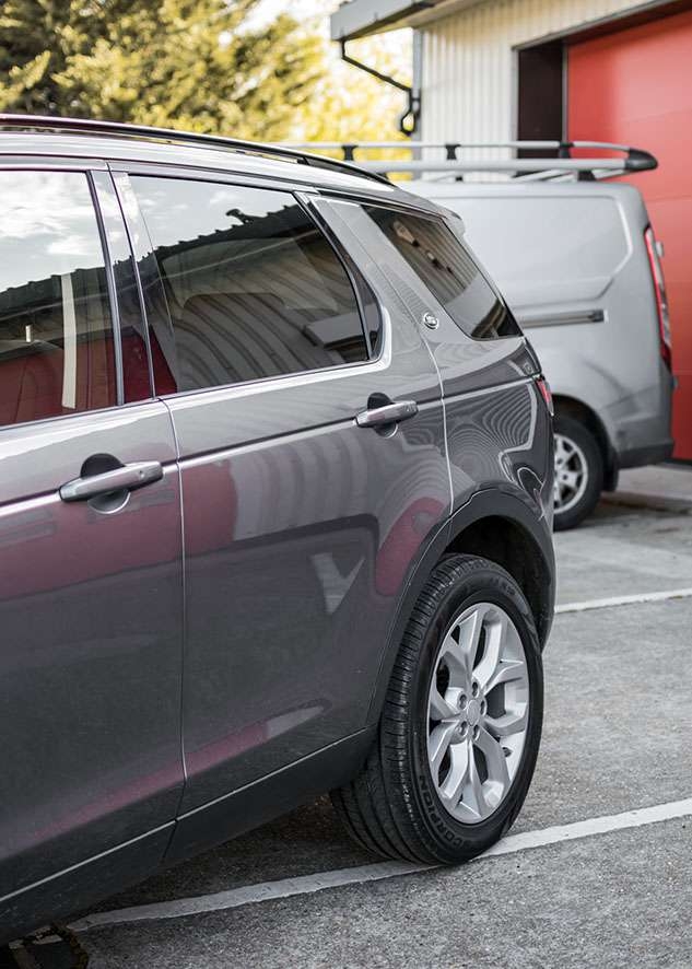 Grey Land Rover Defender with tinted side windows after window tinting