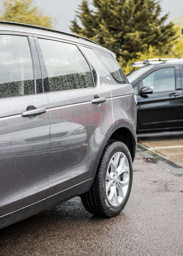 Grey Land Rover Defender with untinted side windows before window tinting