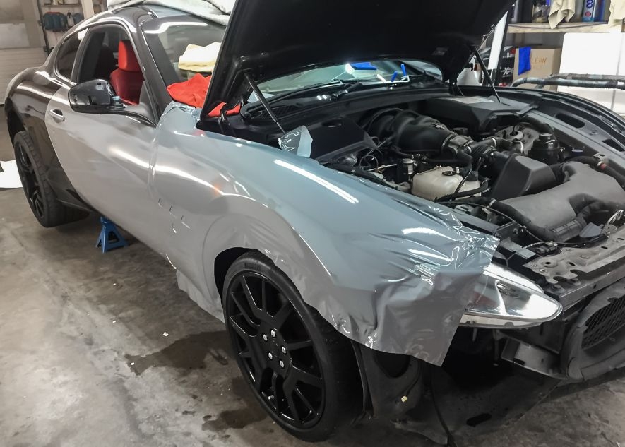 Maserati GranTurismo car being vinyl wrapped in khaki green