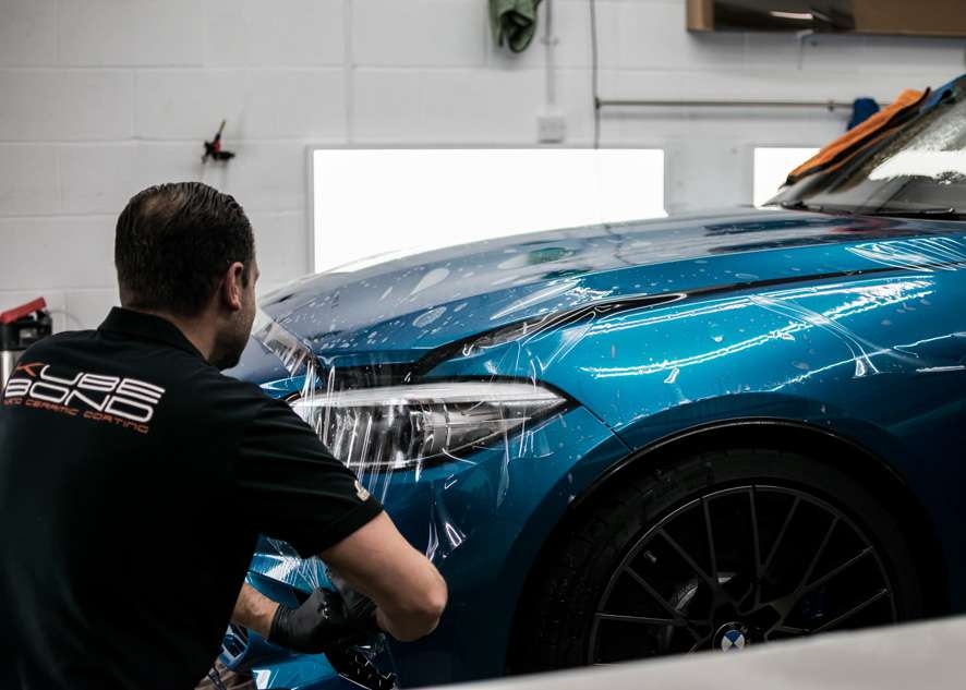 Paint protection film (PPF) being applied to bonnet/hood of blue BMW M2C