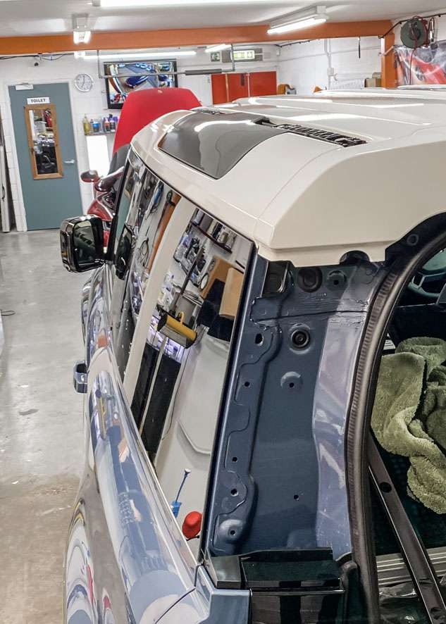 White vinyl wrap applied to roof of Blue Land Rover Defender