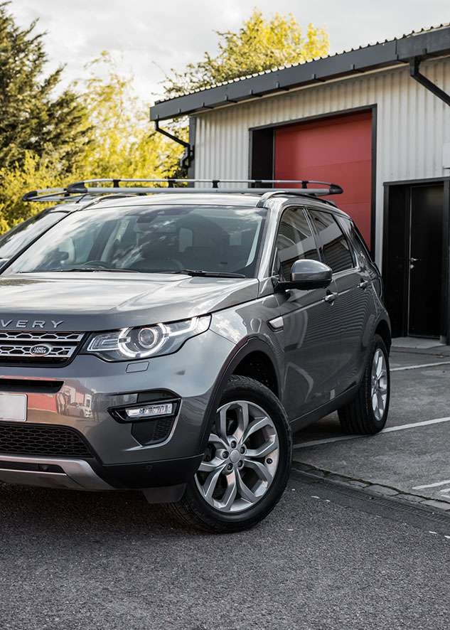 Grey Land Rover Defender car with tinted side windows after window tinting
