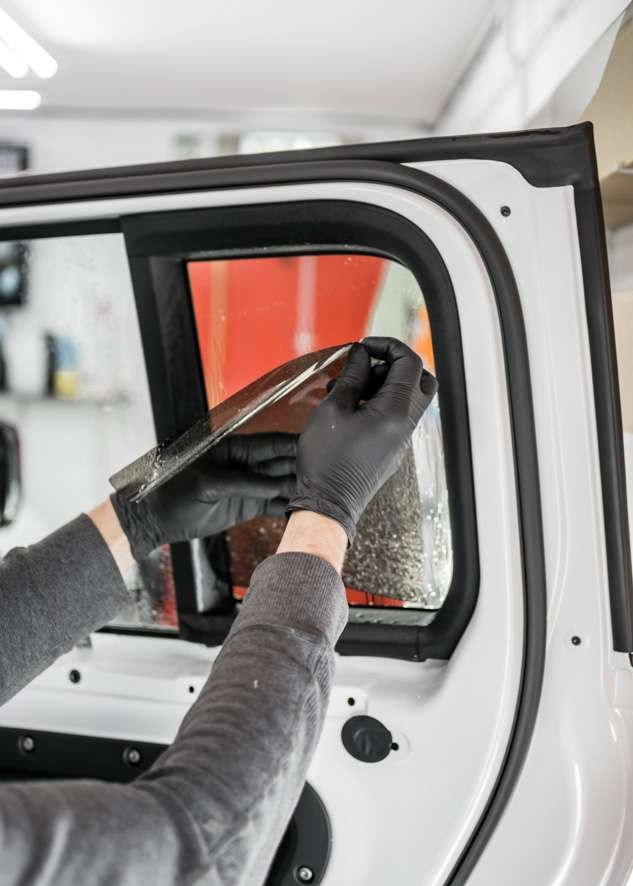 White Land Rover Defender car rear window being tinted