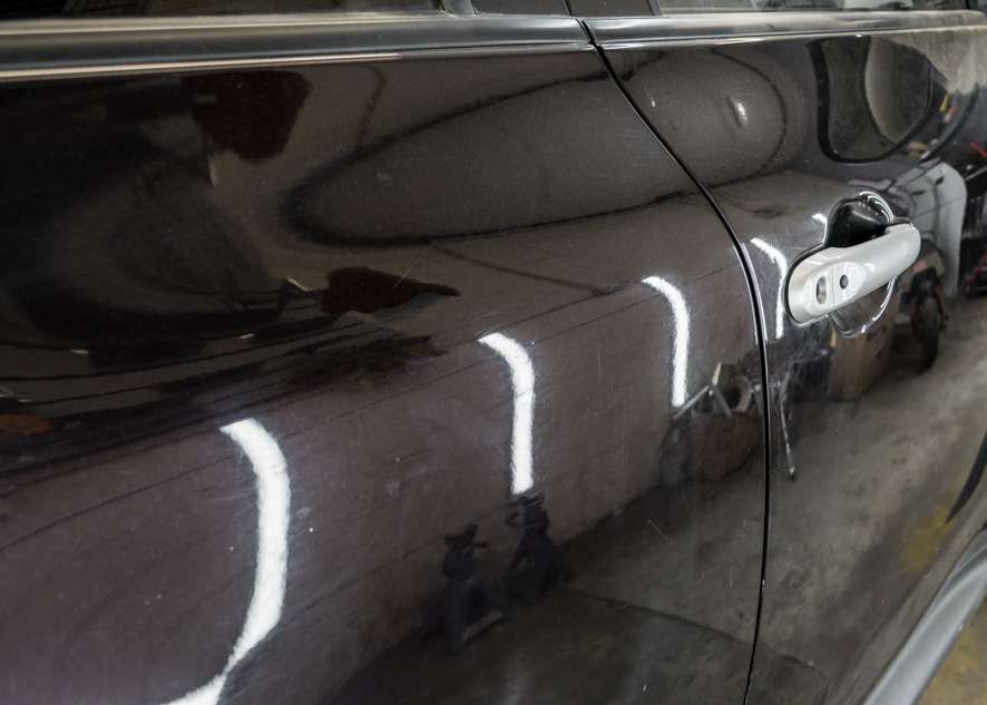 Close up dull and scratched paintwork of black Nissan Juke car before paint correction